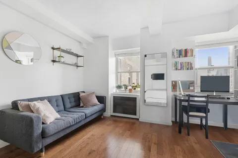a living room with stainless steel appliances furniture and a kitchen view