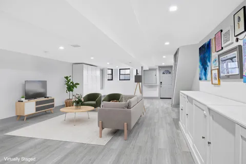 a living room with furniture and a wooden floor