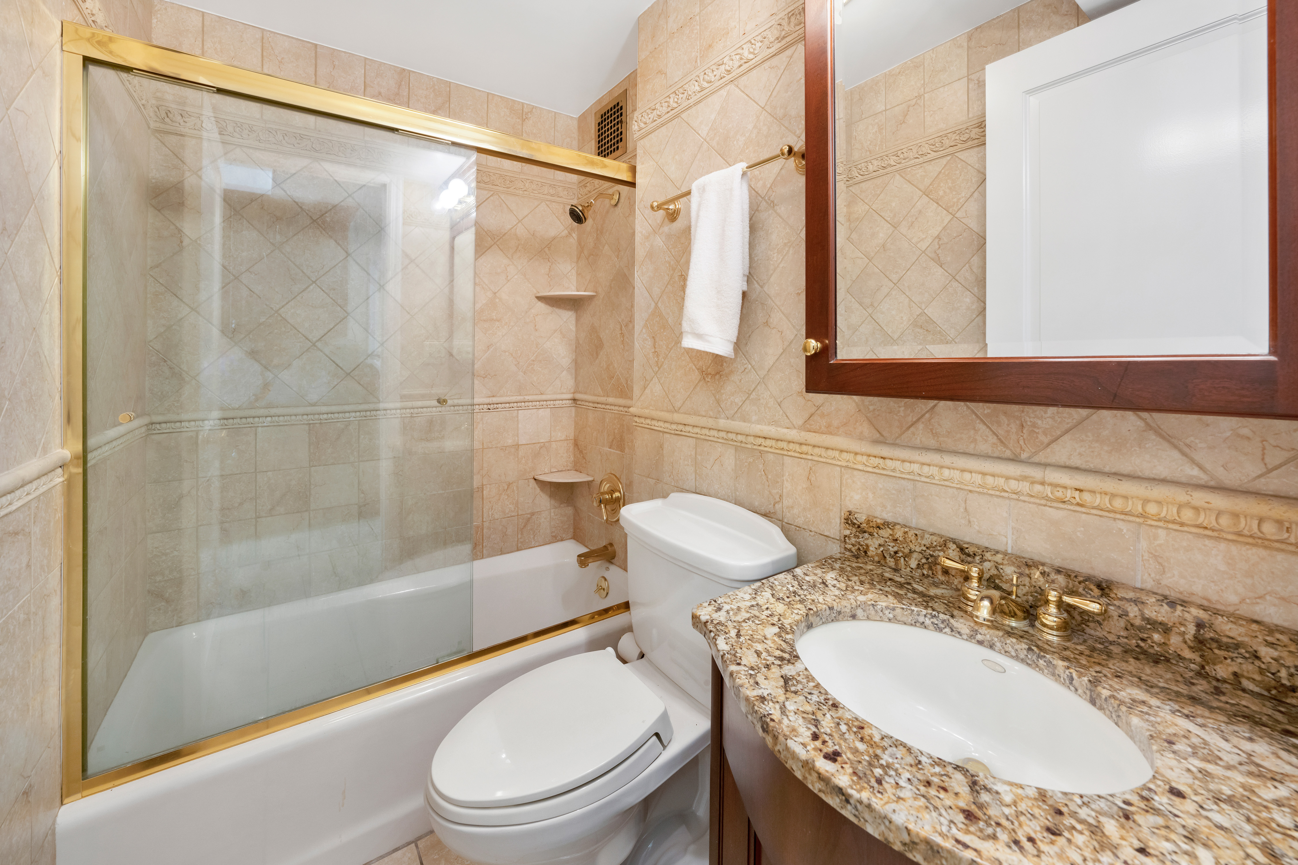 47 East 88th Street, Unit 15A Manhattan, NY 10128 - Photo 16 of 21 a bathroom with a granite countertop sink toilet a mirror and shower