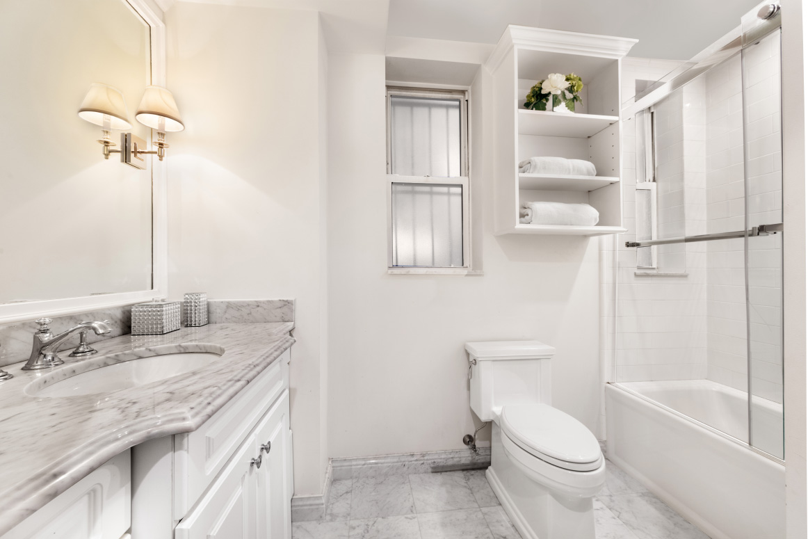 130 East 94th Street, Unit 1A Manhattan, NY 10128 - Photo 6 of 11 a bathroom with a granite countertop sink toilet and shower