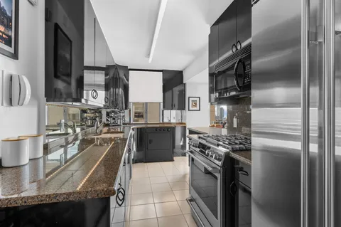a kitchen with stainless steel appliances granite countertop a sink a stove and a refrigerator