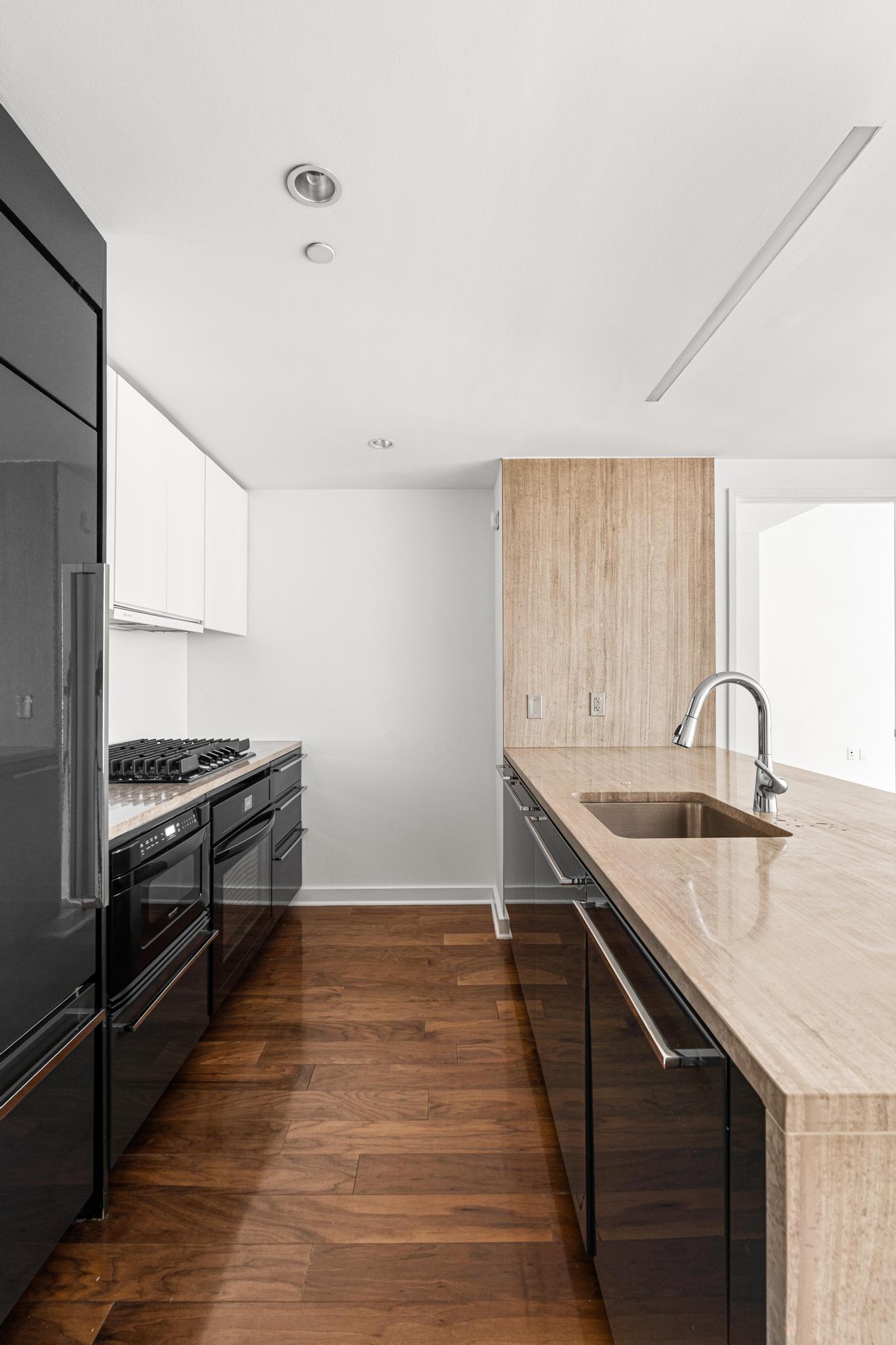 2 Northside Piers, Unit 5U Brooklyn, NY 11249 - Photo 3 of 12 a kitchen with granite countertop a sink a stove and oven