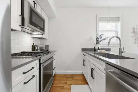 a kitchen with stainless steel appliances granite countertop a sink stove top oven and microwave