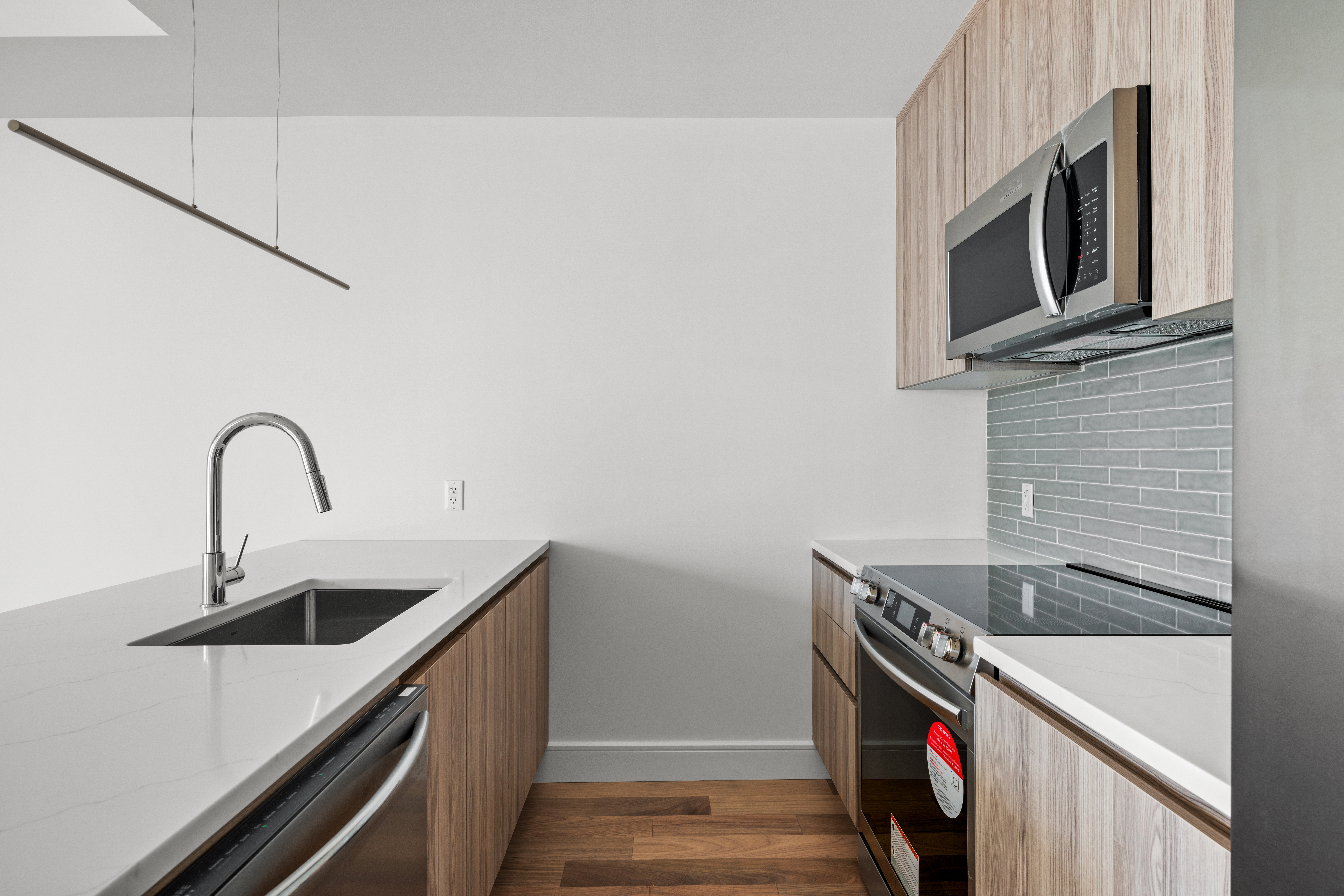 82 Cooper Street, Unit 2B Brooklyn, NY 11207 - Photo 6 of 17 a kitchen with stainless steel appliances granite countertop a sink and a microwave