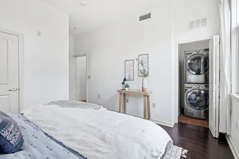 a bedroom with a washing machine and a sink