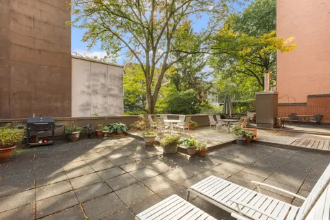 a view of a patio with table and chairs under an umbrella