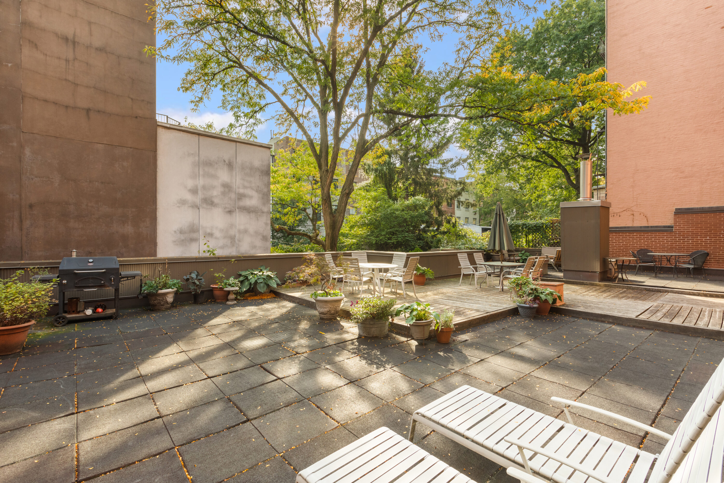 238 Clinton Street, Unit DE Brooklyn, NY 11201 - Photo 16 of 19 a view of a patio with table and chairs under an umbrella