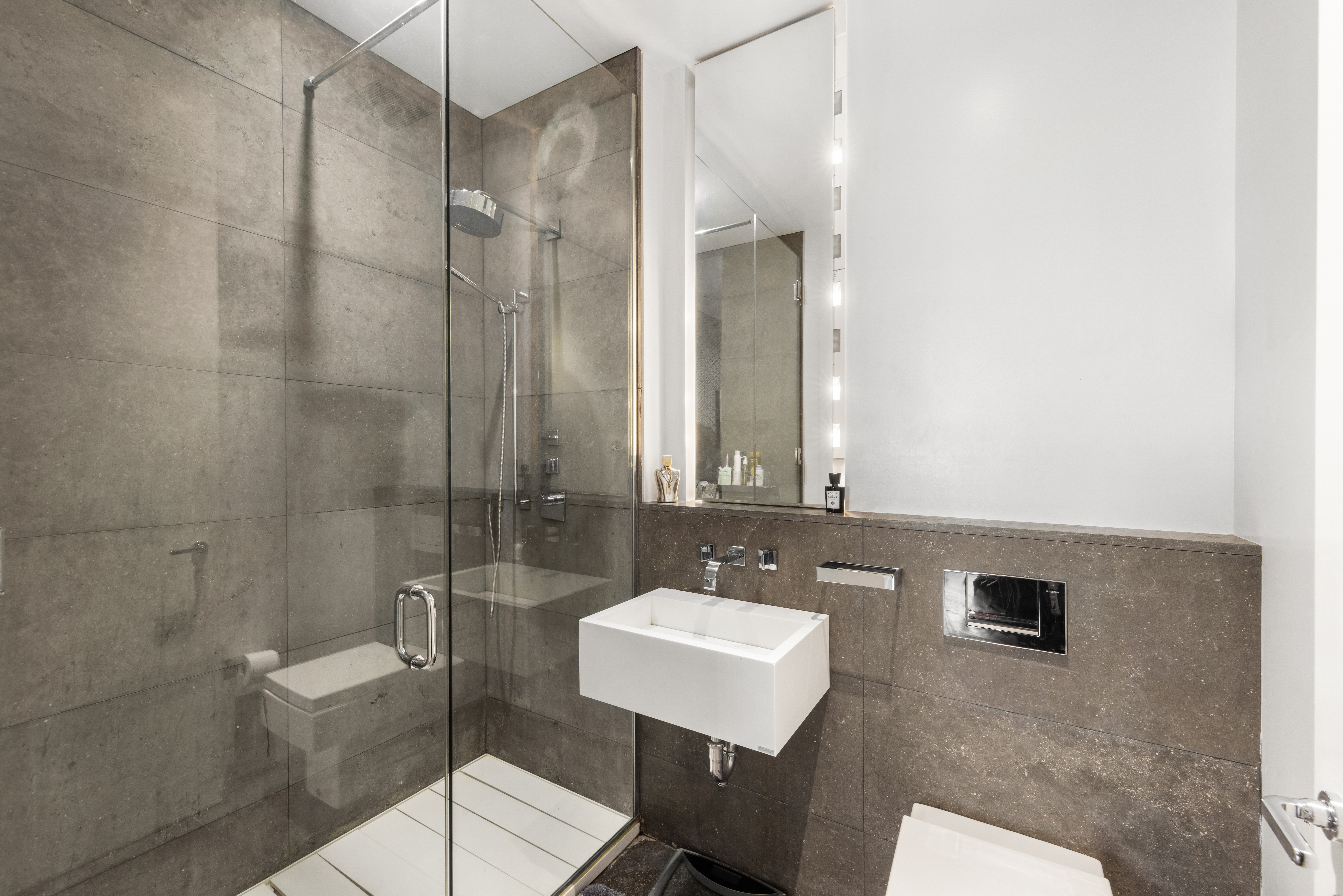 350 East 82nd Street, Unit 14AB Manhattan, NY 10028 - Photo 18 of 21 a bathroom with a sink toilet a mirror and shower