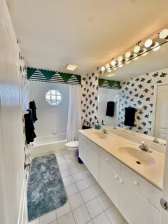 a bathroom with a sink mirror and shower