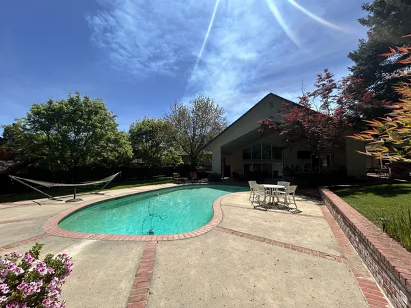a view of a house with a big yard and large trees