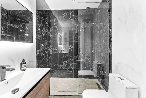 a bathroom with a granite countertop sink a toilet and shower