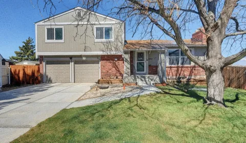 a front view of a house with a yard and potted plants