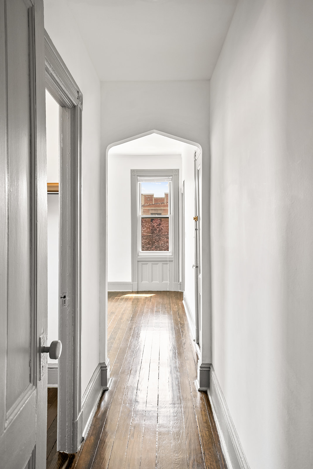 59-45 Palmetto Street Queens, NY 11385 - Photo 14 of 25 a view of a hallway with wooden floor and a window