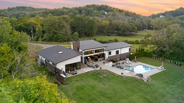 a large kitchen with stainless steel appliances granite countertop a stove and cabinets with wooden floor