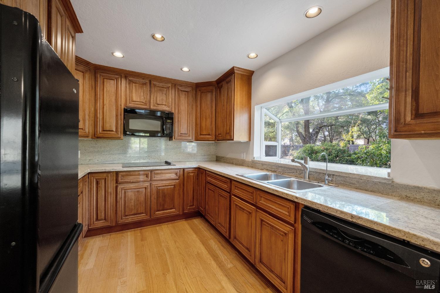 1350 Wooden Valley Road Napa, CA 94558 - Photo 4 of 6 a kitchen with stainless steel appliances granite countertop sink stove microwave refrigerator and cabinets