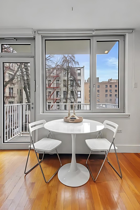 154 Attorney Street, Unit 304 Manhattan, NY 10002 - Photo 4 of 13 a living room with furniture a table and a large window