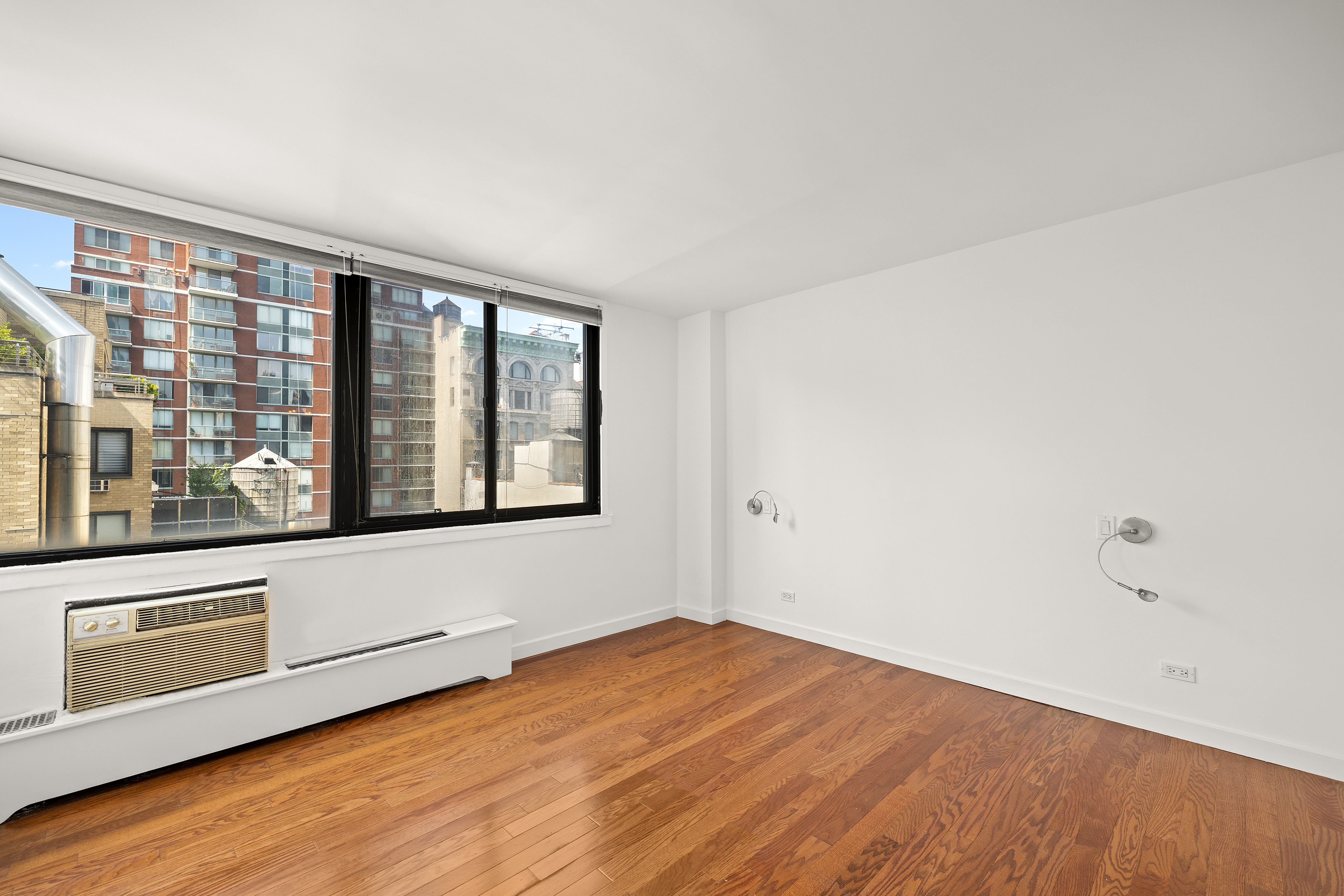 16 West 16th Street, Unit 14NN Manhattan, NY 10011 - Photo 4 of 10 a view of an empty room with wooden floor and a window