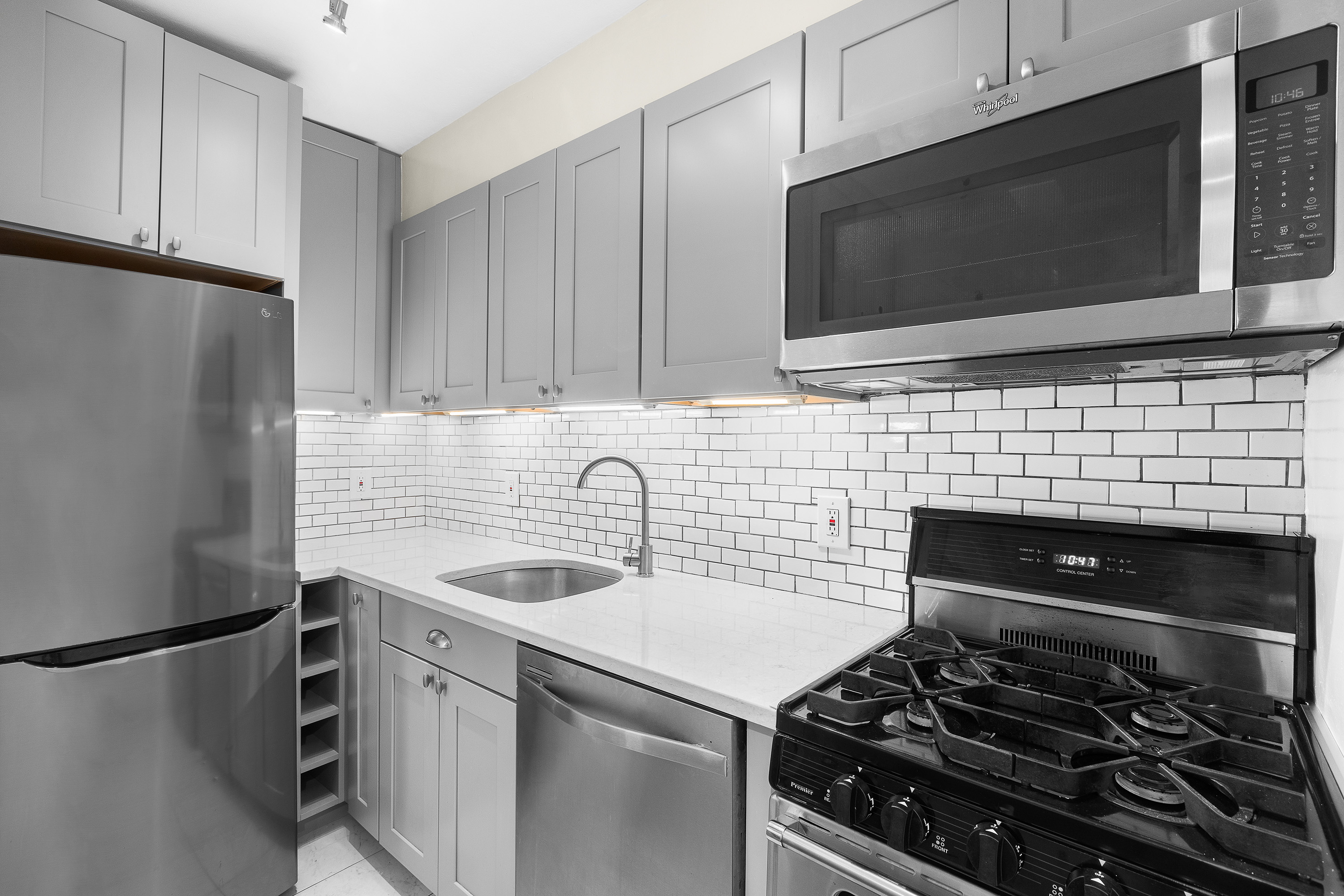139 East 33rd Street, Unit 15G Manhattan, NY 10016 - Photo 8 of 11 a kitchen with stainless steel appliances a stove a sink and a microwave
