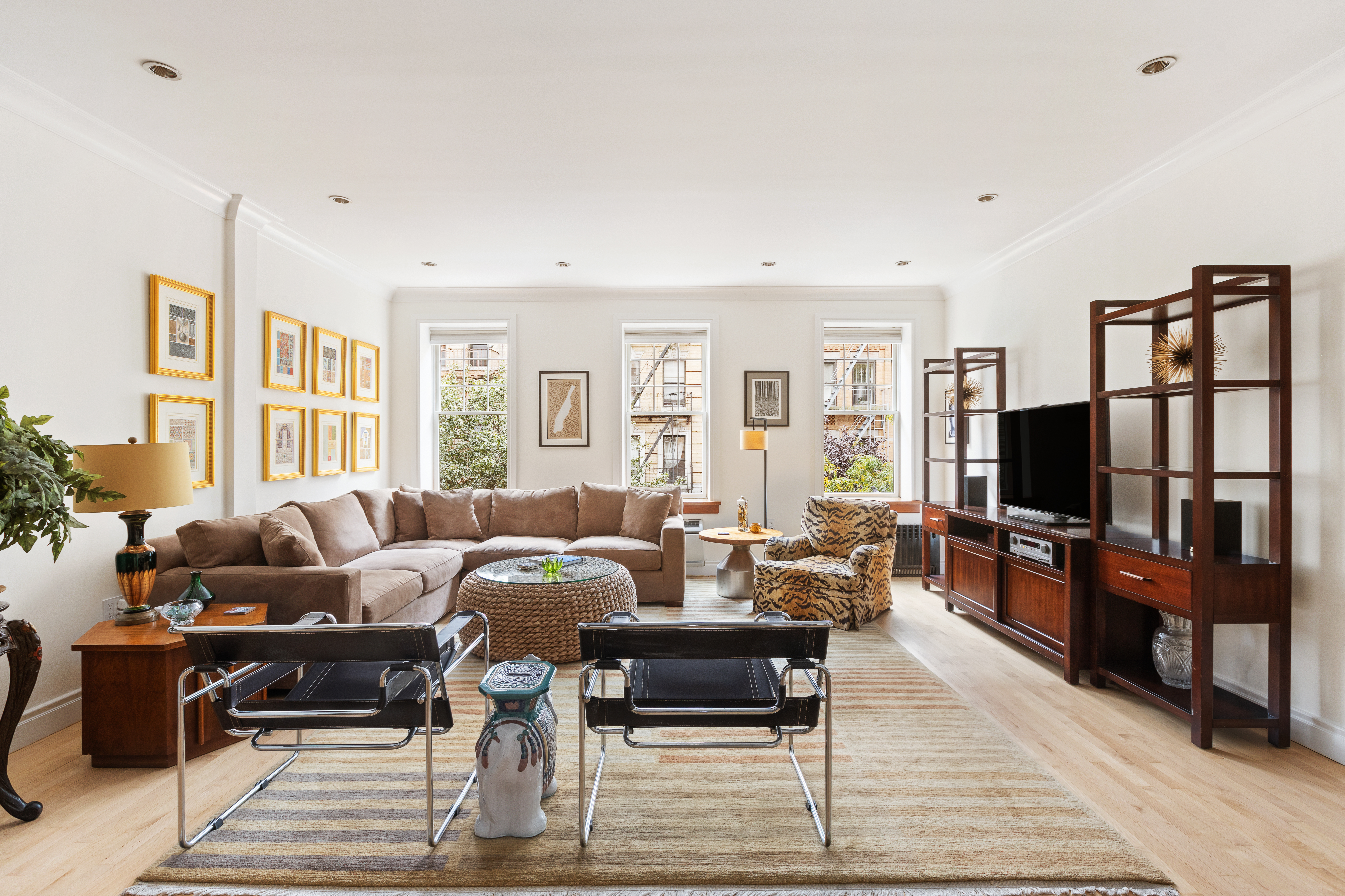 203 East 7th Street, Unit 2 Manhattan, NY 10009 - Photo 1 of 9 a living room with furniture a rug and a flat screen tv