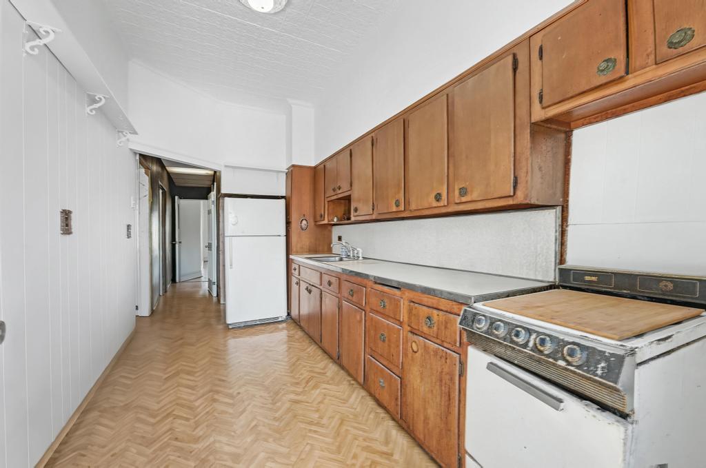 10 Seeley Street Brooklyn, NY 11218 - Photo 7 of 27 a kitchen with granite countertop a stove top oven a refrigerator and cabinets