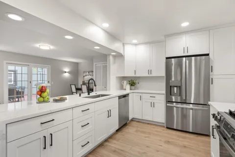 a kitchen with stainless steel appliances white cabinets a stove a microwave and a refrigerator