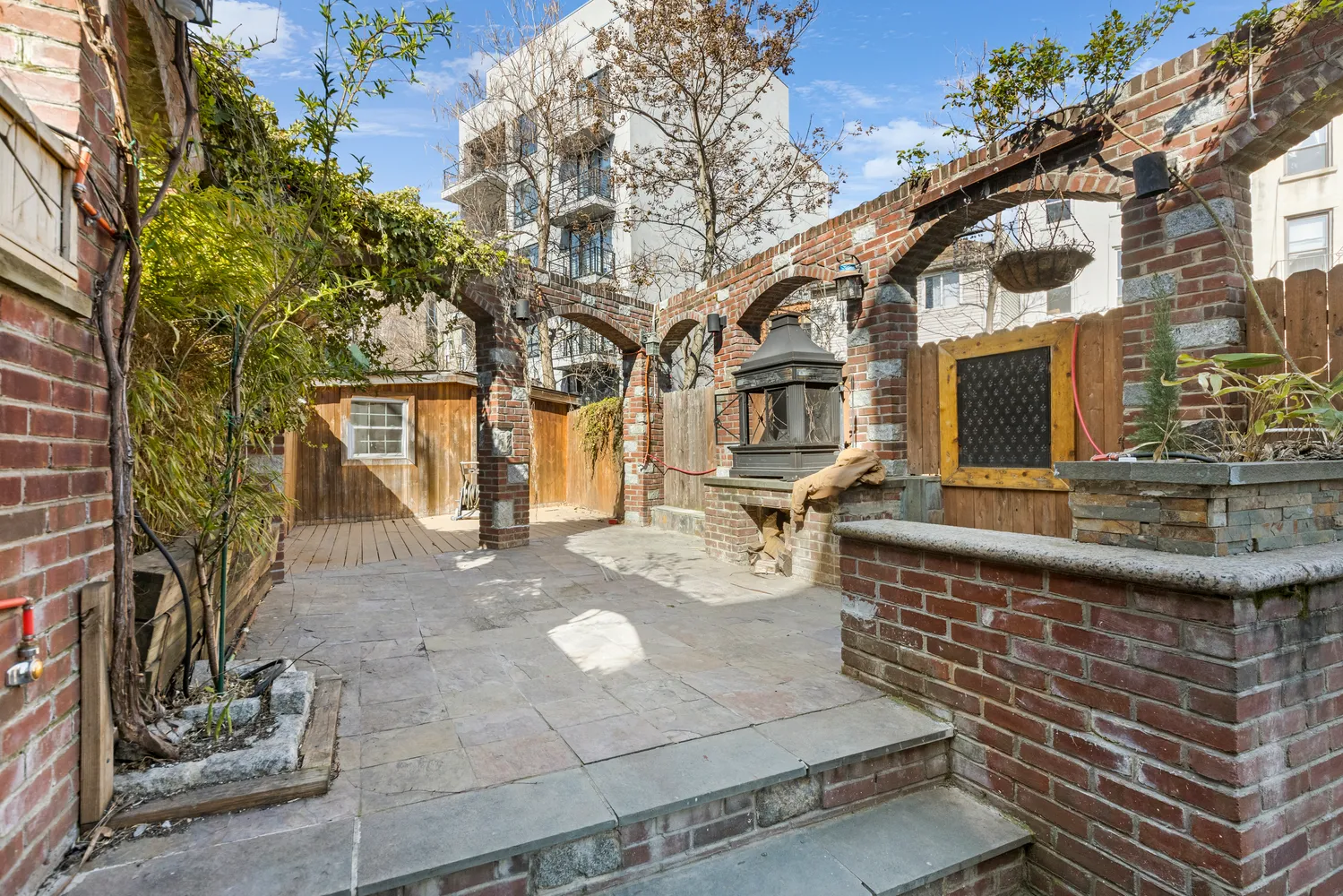 a front view of a house with large tree and plants
