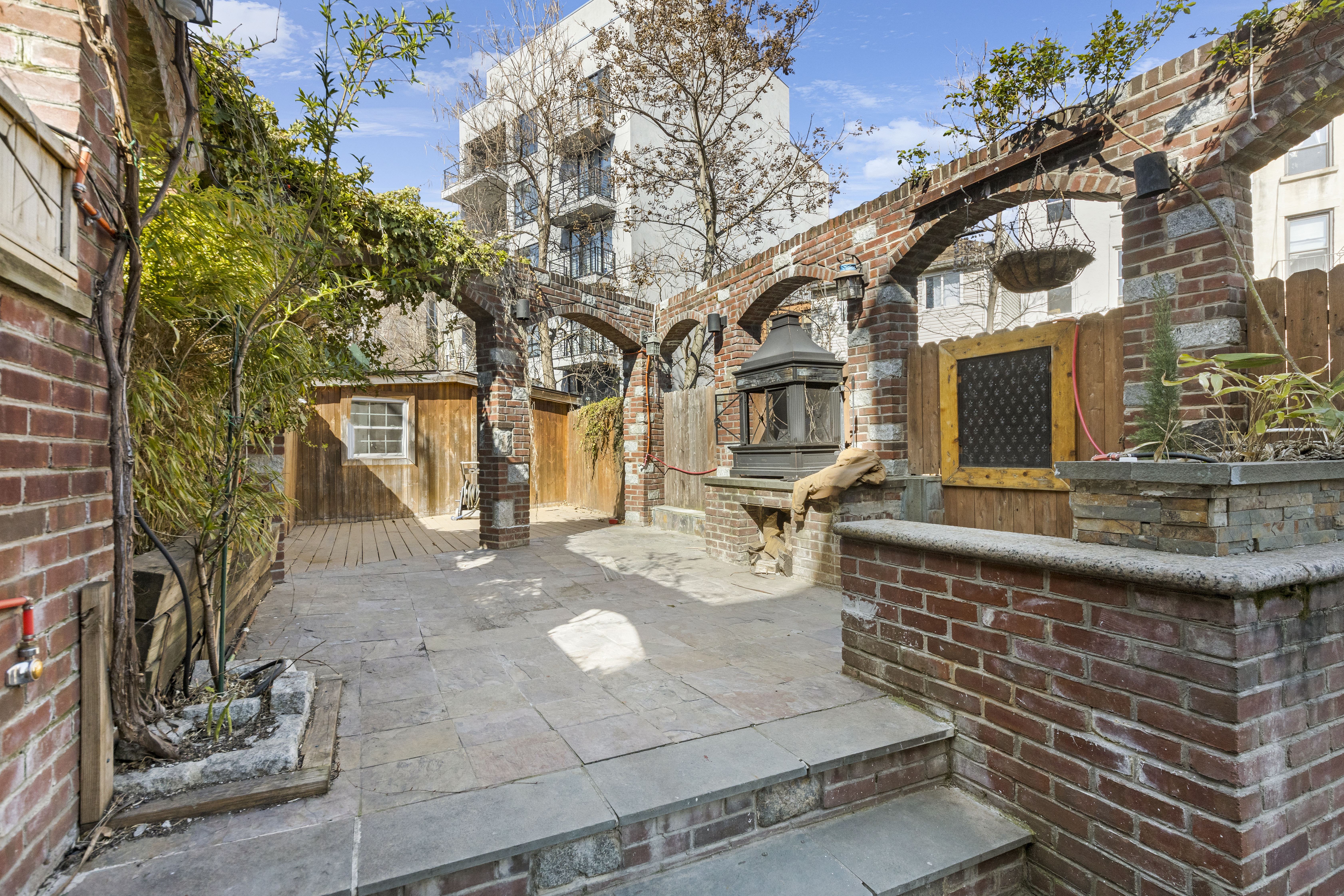 1061 Fulton Street, Unit 1 Brooklyn, NY 11238 - Photo 12 of 13 a front view of a house with large tree and plants
