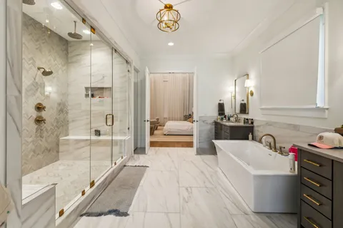 a en suite spacious bathroom with a tub shower and window