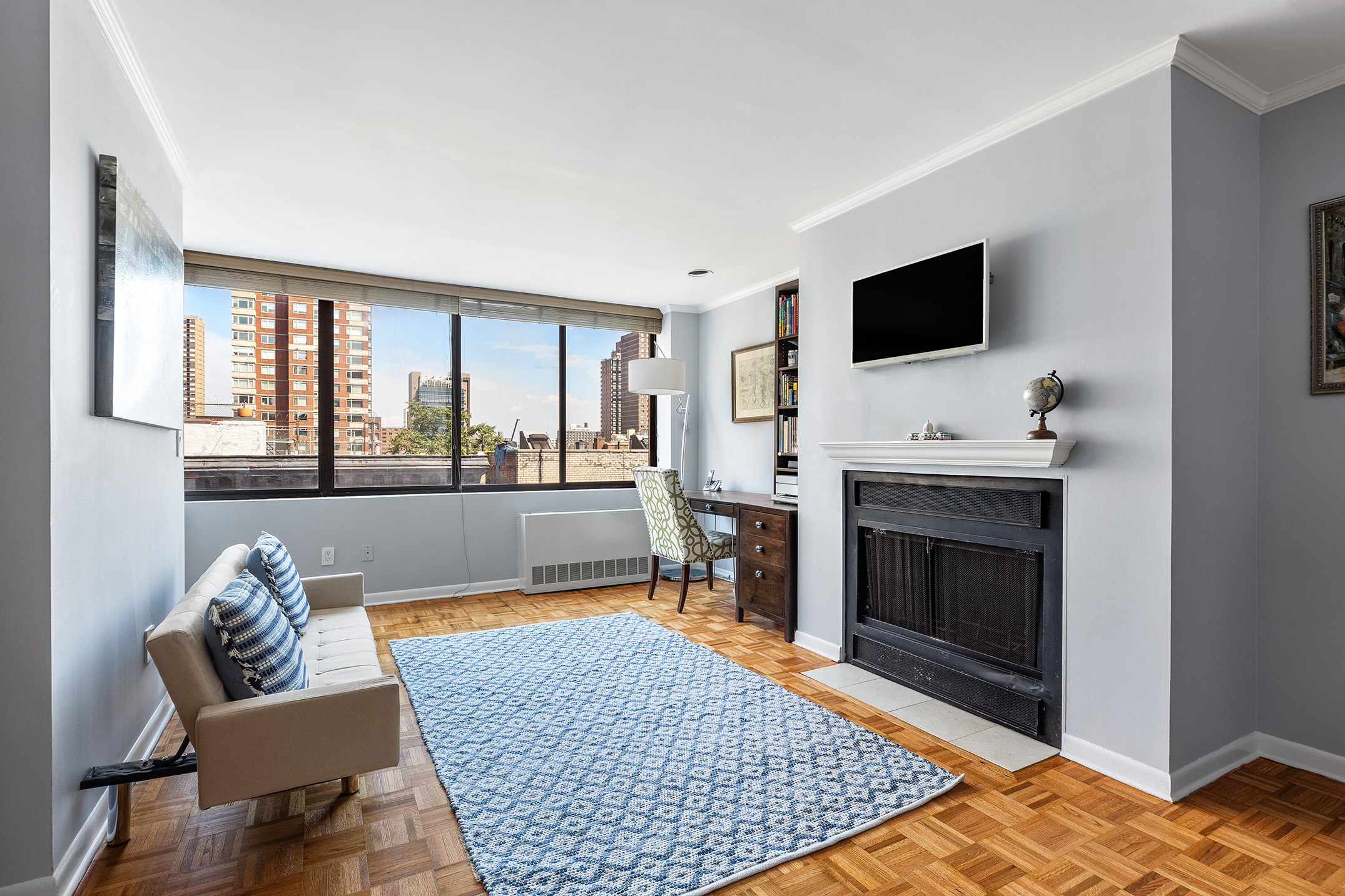 300 East 90th Street, Unit 7C Manhattan, NY 10128 - Photo 1 of 12 a living room with furniture fireplace and flat screen tv