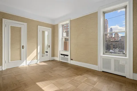 a view of an empty room with window and bathroom
