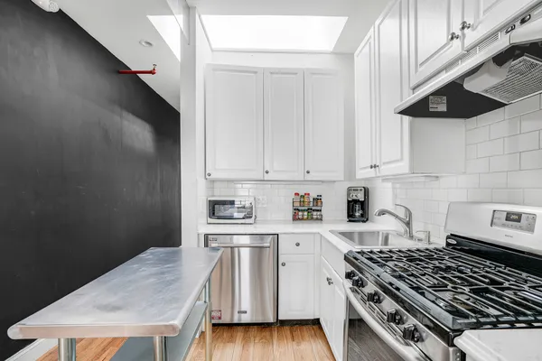 a kitchen with a stove and a white cabinet
