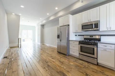 a kitchen with stainless steel appliances granite countertop a stove a refrigerator and a microwave