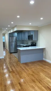 a large kitchen with stainless steel appliances a large counter top a stove and a refrigerator