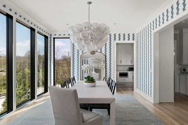 a kitchen with stainless steel appliances granite countertop a table chairs refrigerator and sink