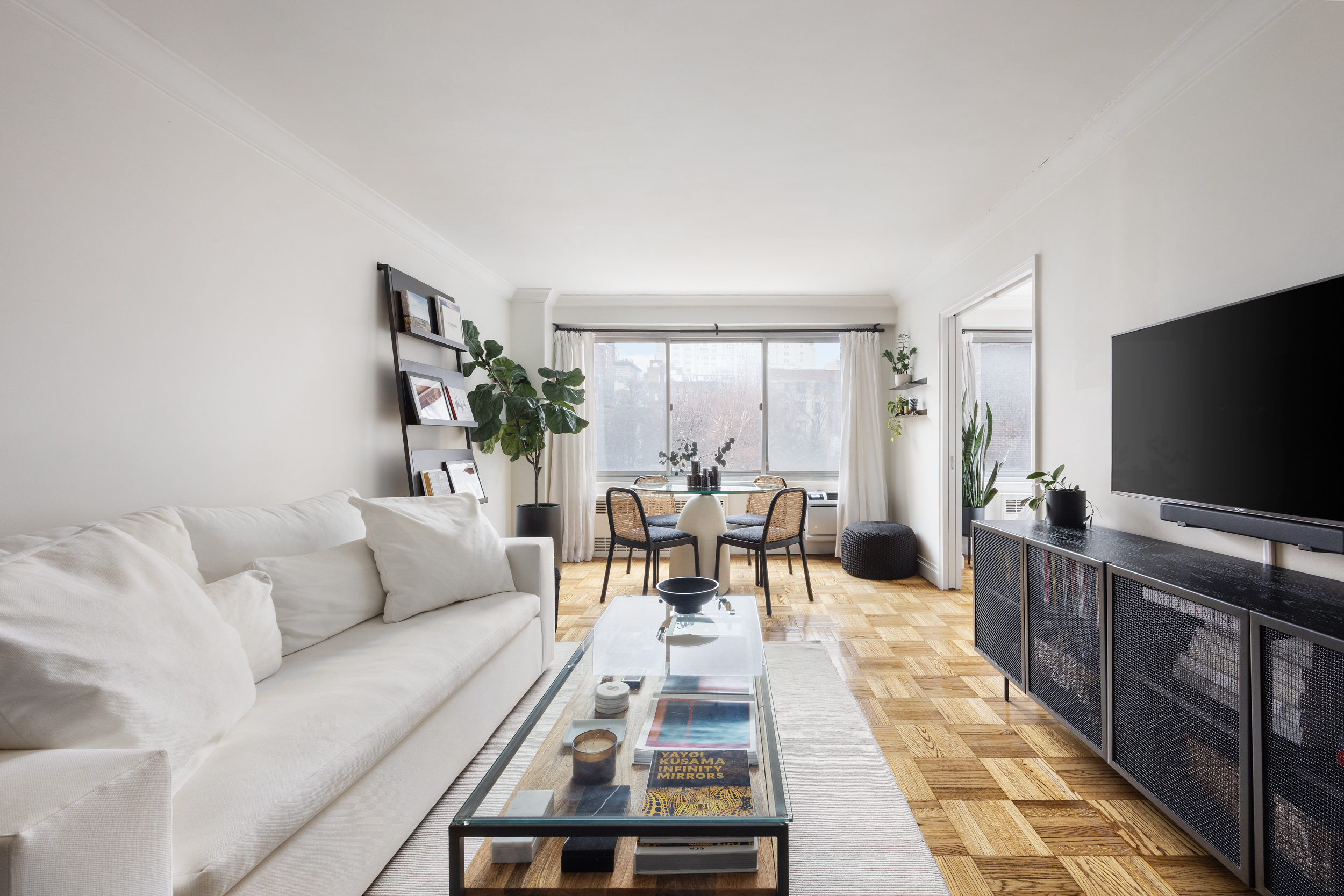 175 West 12th Street, Unit 4L Manhattan, NY 10011 - Photo 2 of 11 a living room with furniture and a flat screen tv