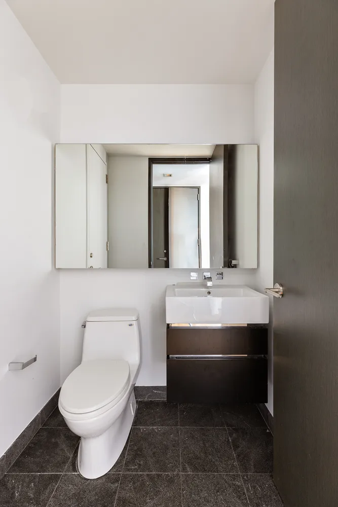 a bathroom with a toilet sink and mirror