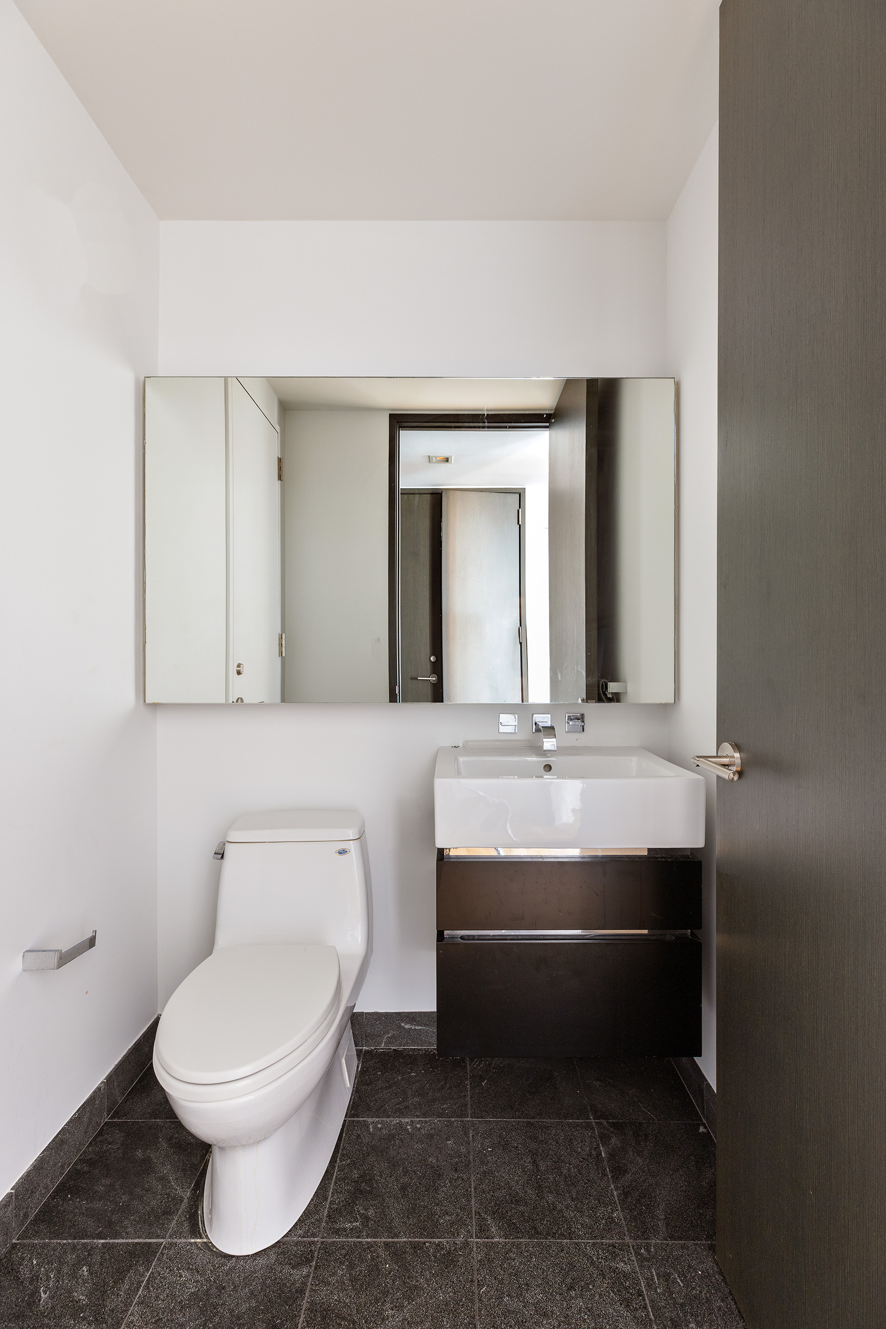 247 West 46th Street, Unit 3103 Manhattan, NY 10036 - Photo 8 of 14 a bathroom with a toilet sink and mirror