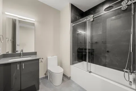 a bathroom with a bathtub shower sink vanity and toilet