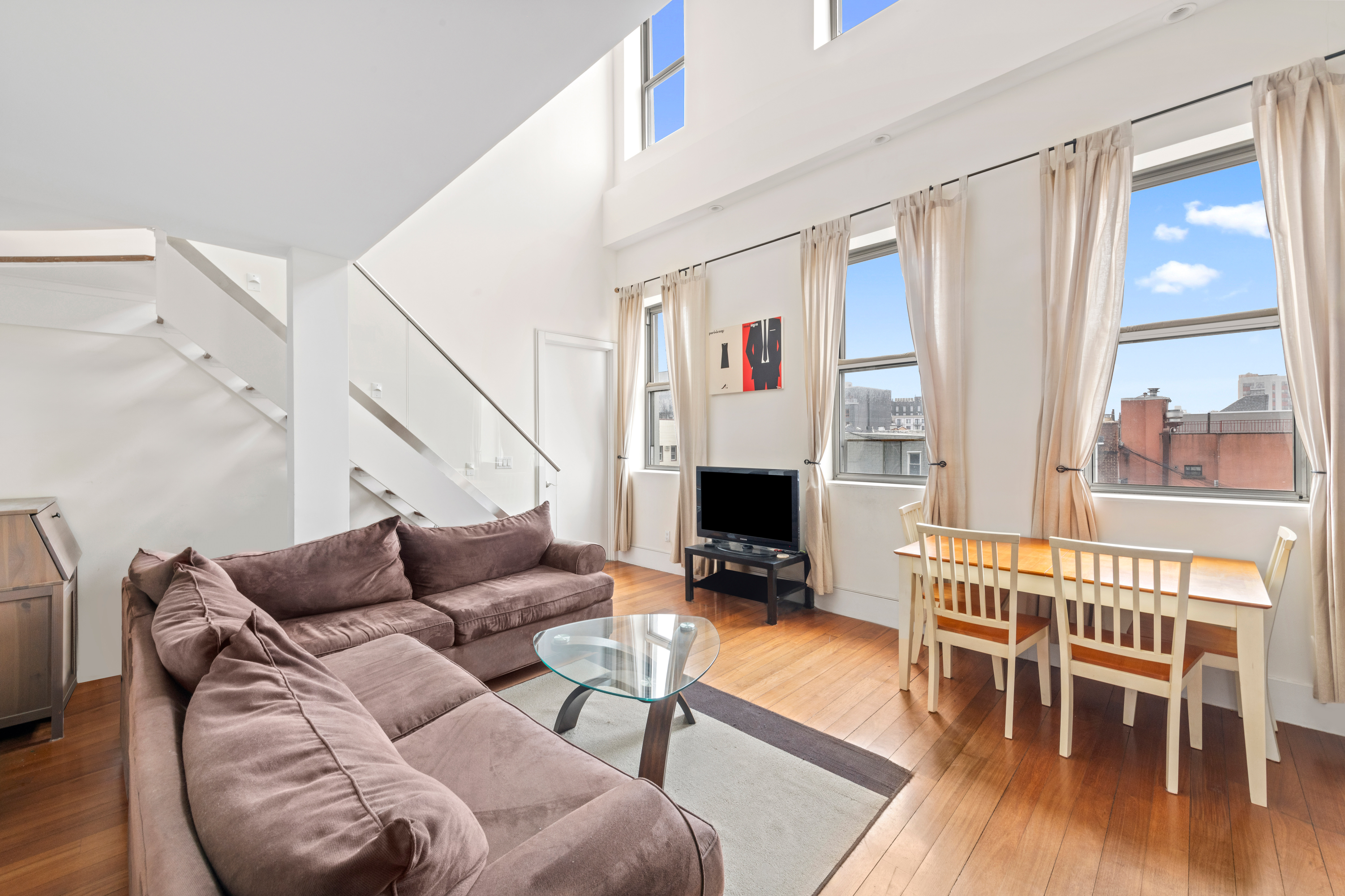 a living room with furniture a fireplace and a floor to ceiling window