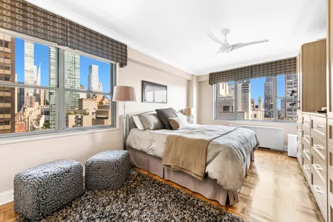 a spacious bedroom with a bed couch and a large window