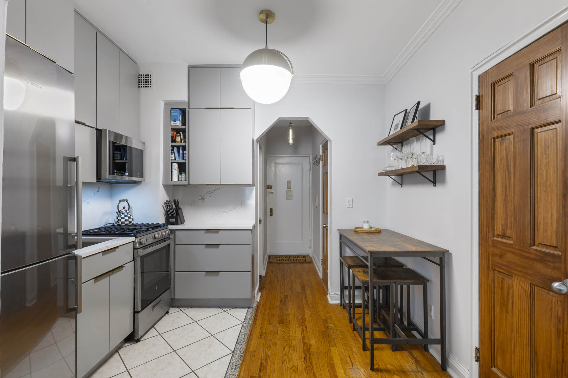 242 East 87th Street, Unit 2B Manhattan, NY 10128 - Photo 4 of 10 a kitchen with stainless steel appliances granite countertop a refrigerator a stove and a sink