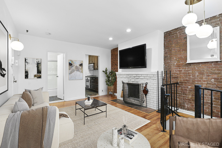 24 West 83rd Street, Unit 1F Manhattan, NY 10024 - Photo 2 of 6 a living room with furniture a fireplace and a flat screen tv