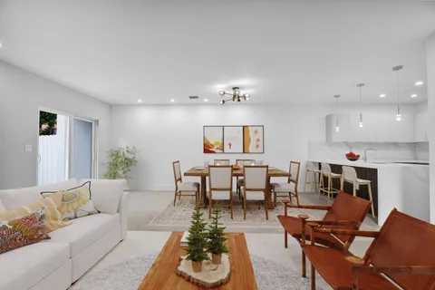 a living room with furniture and a dining table with kitchen view