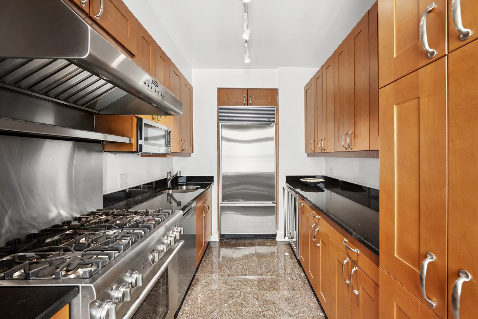 99 Jane Street, Unit 4H Manhattan, NY 10014 - Photo 8 of 22 a kitchen with stainless steel appliances granite countertop a stove and a refrigerator