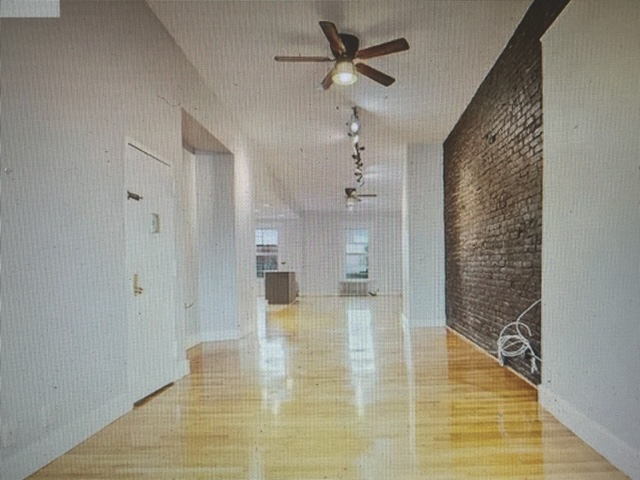 250 57th Street Brooklyn, NY 11220 - Photo 3 of 15 a view of empty room with wooden floor and fan