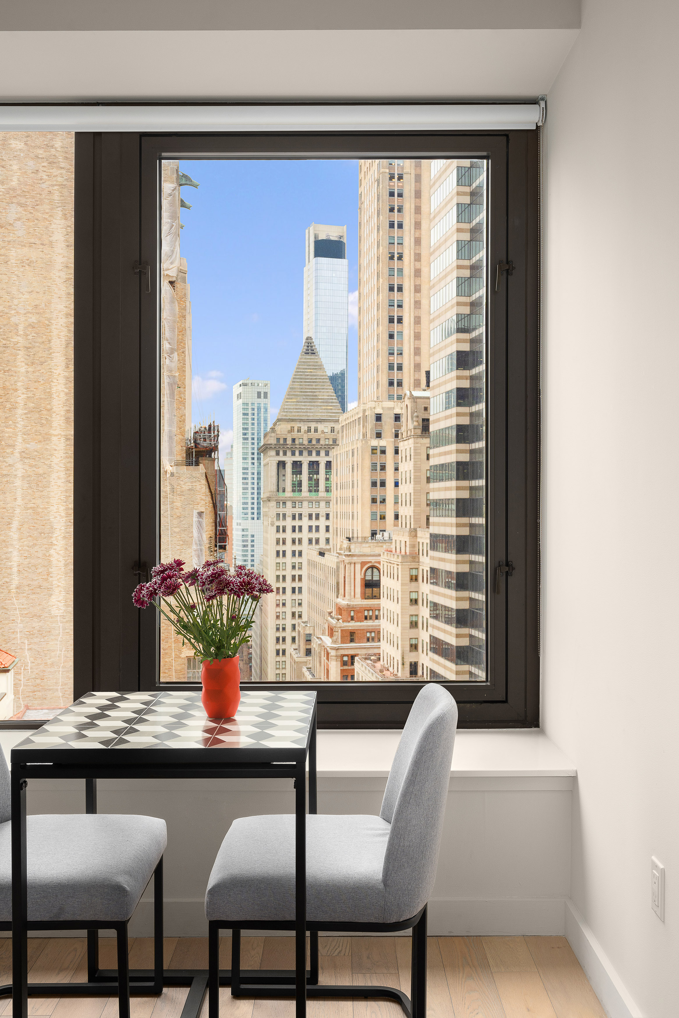 75 Wall Street, Unit 33L Manhattan, NY 10005 - Photo 3 of 5 a dining room with furniture and window