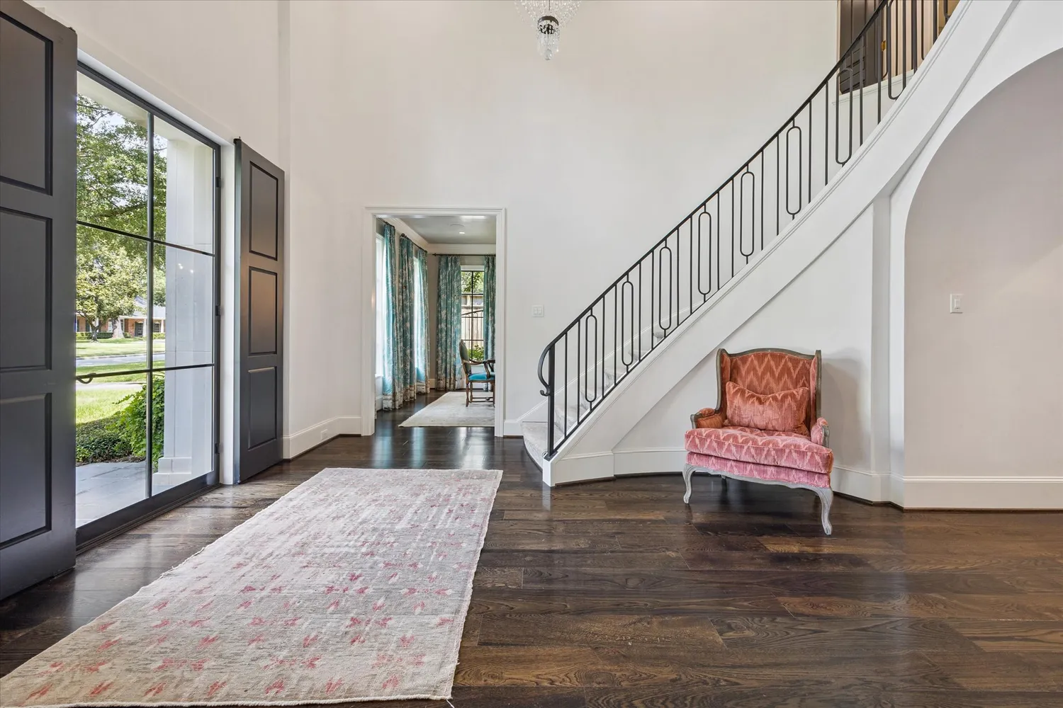 a view of a hallway with wooden floor stairs and a livingroom