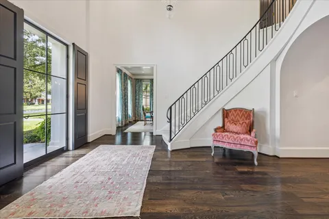 a view of a hallway with wooden floor stairs and a livingroom