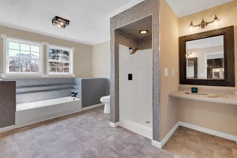 a spacious bathroom with a bathtub sink and mirror