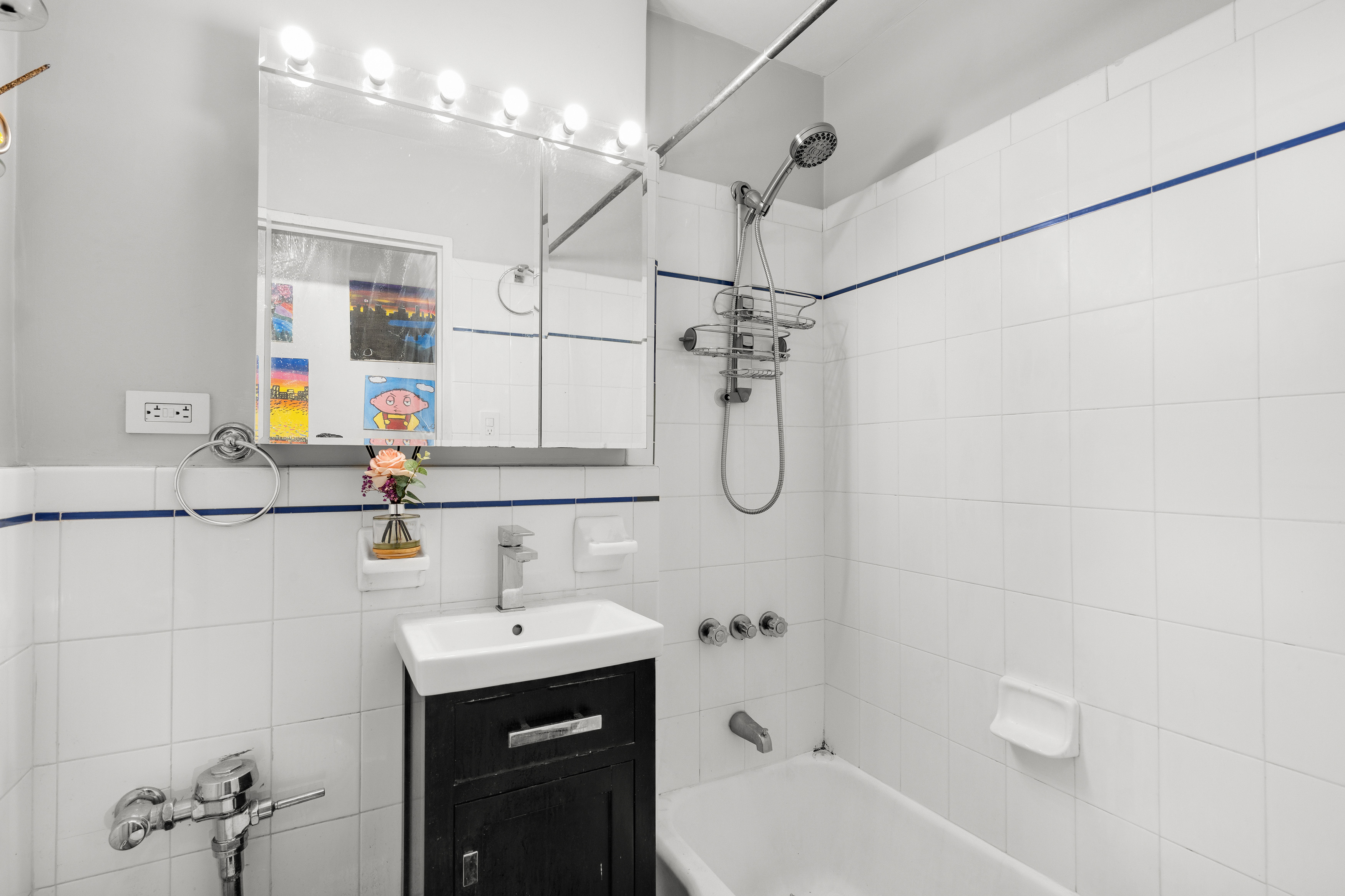 421 West 57th Street, Unit 3C Manhattan, NY 10019 - Photo 5 of 18 a bathroom with a sink vanity granite tub shower and mirror